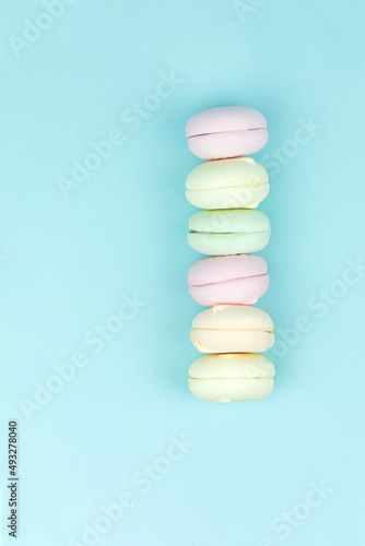Multi Colored Stacked Up French marshmallow looks like Macarons on Blue, concept of sweet dessert.