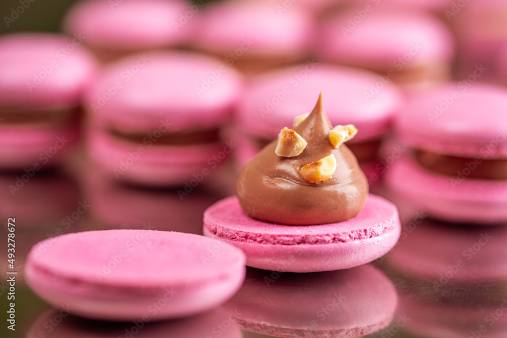 Macarons closeup on white wooden background. Sweet and colourful pink french macaroons. Cooking at home. Macarons closeup on white wooden background. Sweet and colourful pink french macaroons. Cooking at home.