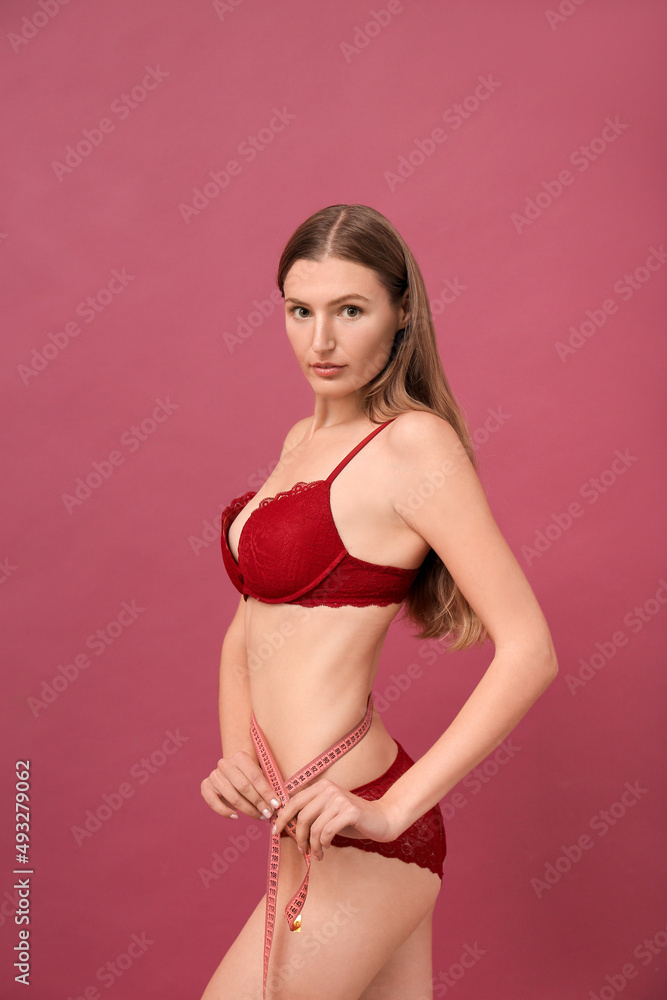 Beautiful thin girl measures her waist with a meter tape Beautiful thin girl measures her waist with a meter tape