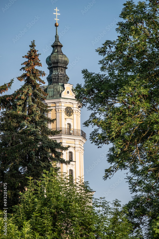 Kloster Heilig Kreuz Kirchturm mit Dreierkreuz hinter Bäumen