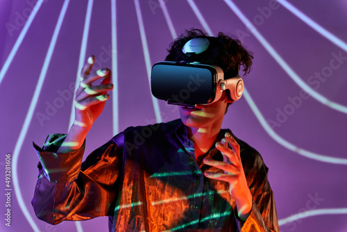 Man in VR headset near wall with lights photo