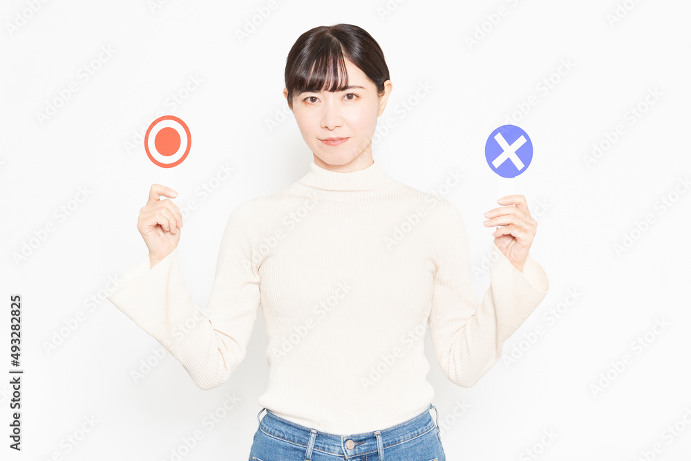 白い背景の前に立ってOKとNGのプラカードを見せている女性 白い背景の前に立ってOKとNGのプラカードを見せている女性