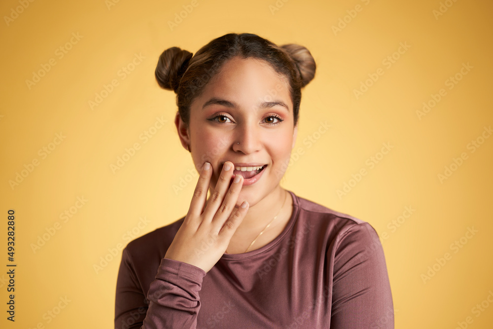 Young Hispanic girl with surprised gesture with hand on her mouth. isolated on yellow background Young Hispanic girl with surprised gesture with hand on her mouth. isolated on yellow background