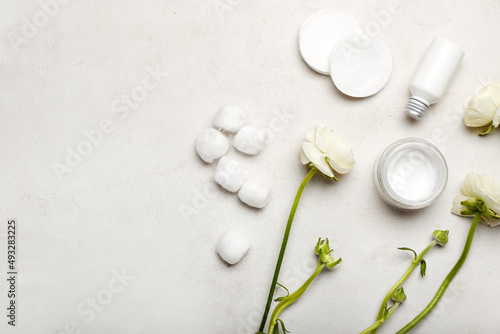 Composition with cosmetic products  cotton pads  balls and ranunculus flowers on light background