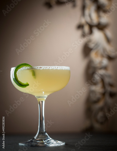 Pale Yellow Cocktail with Green Garnish in Champagne Coupe Glass
