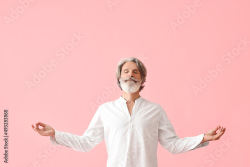Canvastavla Meditating mature man on color background