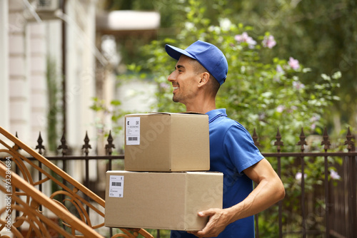 Male courier with parcels outdoors