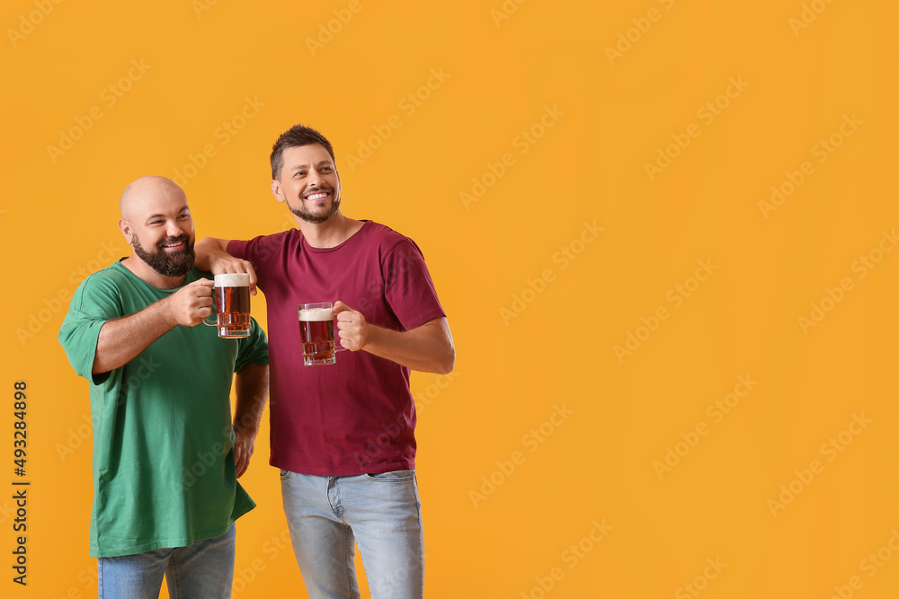 Obraz premium Men drinking beer on yellow background