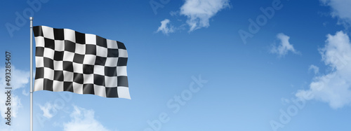 Auto racing finish checkered flag isolated on a blue sky photo