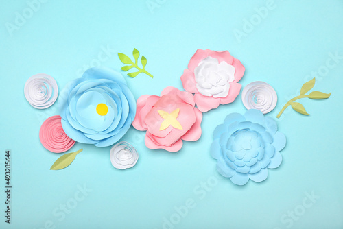 Beautiful handmade paper flowers on blue background
