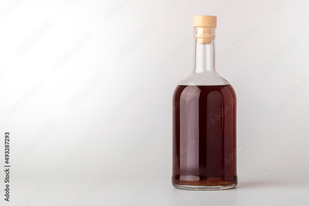 Glass bottle with whiskey alcohol, brandy on a light background with a clean space for text. Space copy