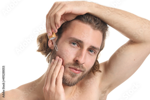 Young man using serum for s...