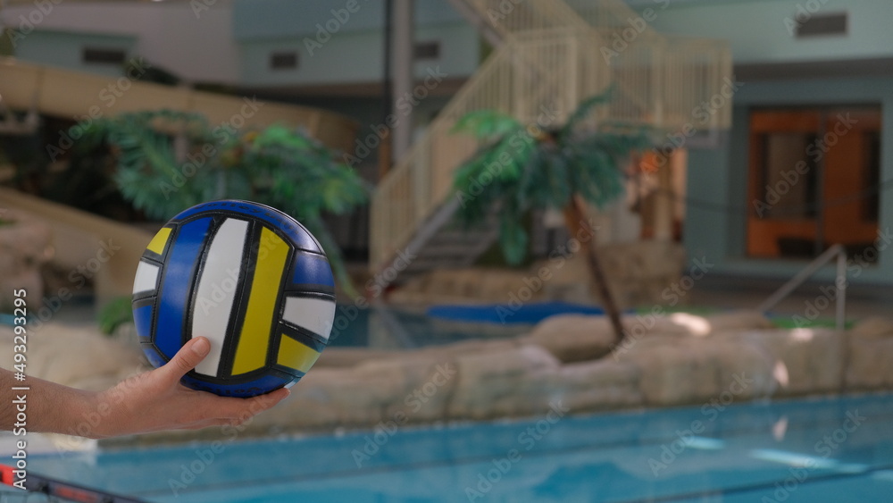 Water polo and sports in the indoor hot pool play volleyball