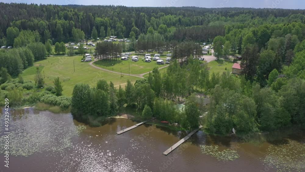 Beautiful drone point of view of a caravan park next to a lake. Awesome trailer lifestyle. Good holiday opportunity. Aerial geology shot with the camera slowly moving upwards. Beautiful drone point of view of a caravan park next to a lake. Awesome trailer lifestyle. Good holiday opportunity. Aerial geology shot with the camera slowly moving upwards.