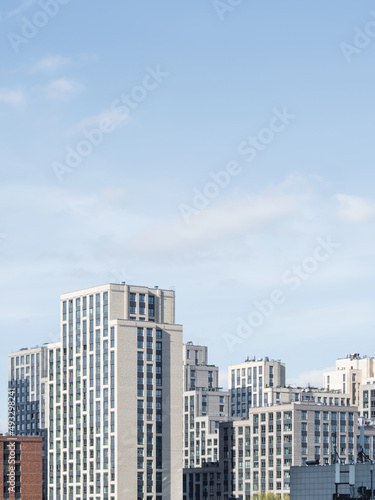 New residential district of Moscow. Modern architecture of apartment buildings. Vertical banner with clear blue sky. Russia.