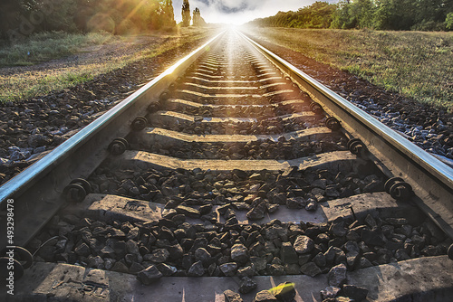 the rails go off into the distance against the background of sunset