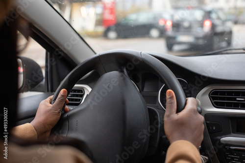 hands of driver on steering wheel, black woman driving