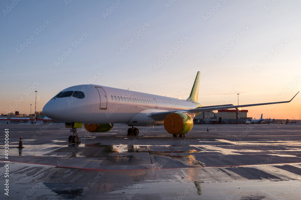 Modern passenger airplane on the airport apron at the evening light Modern passenger airplane on the airport apron at the evening light