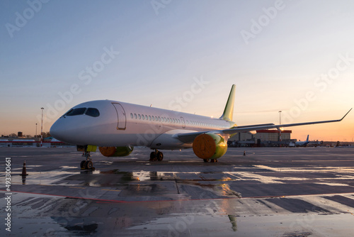 Modern passenger airplane on the airport apron at the evening light