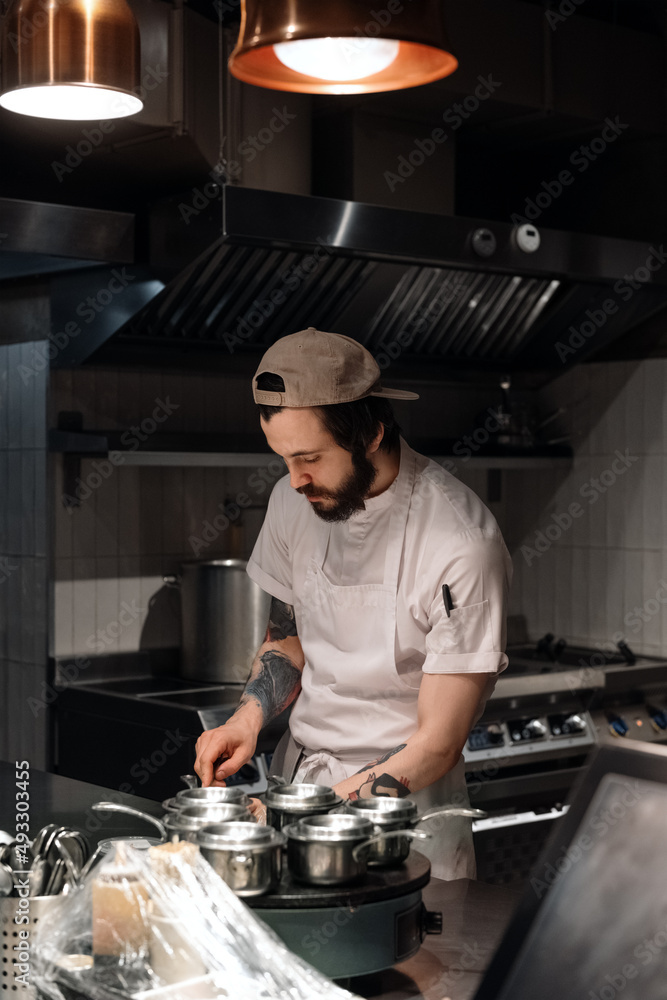 Bearded chef working in restaurant kitchen Bearded chef working in restaurant kitchen
