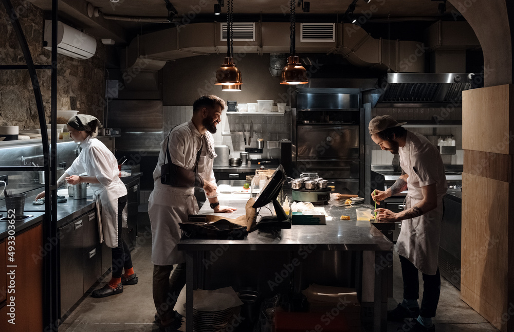 Injured chef working in restaurant with colleagues Injured chef working in restaurant with colleagues