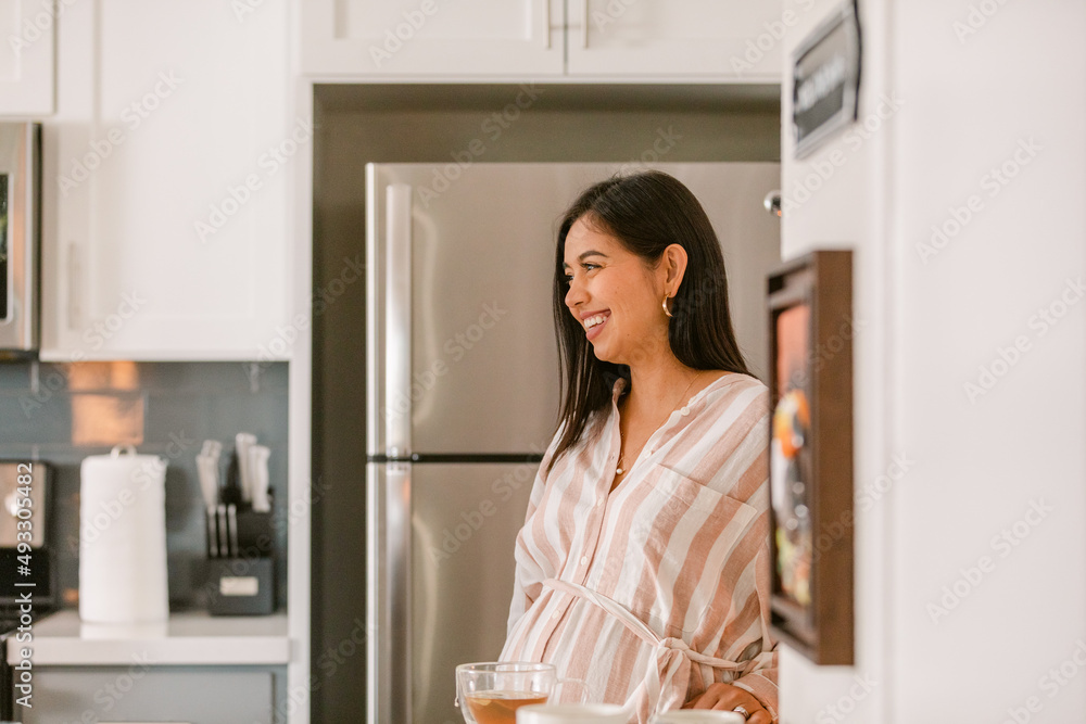 Pregnant Latin woman smiling in kitchen Pregnant Latin woman smiling in kitchen
