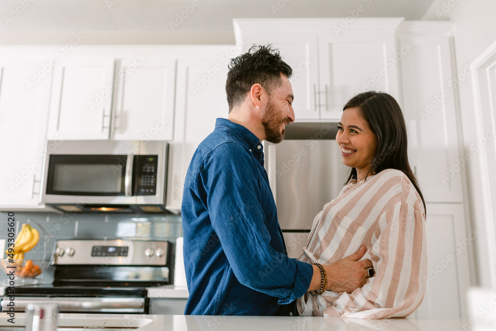 Happy couple in love expecting baby in kitchen Happy couple in love expecting baby in kitchen