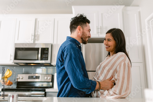 Happy couple in love expecting baby in kitchen photo