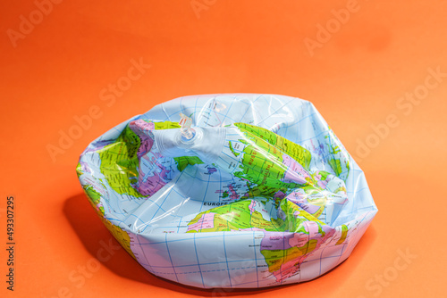 Deflated globe isolated on orange background.