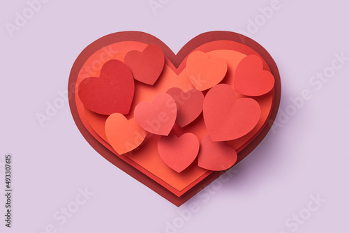 Various papercraft hearts over violet background