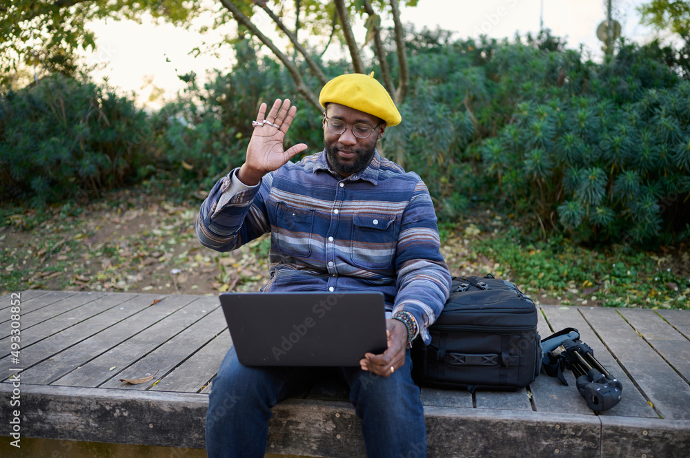 black man livestreaming with his computer in a park black man livestreaming with his computer in a park