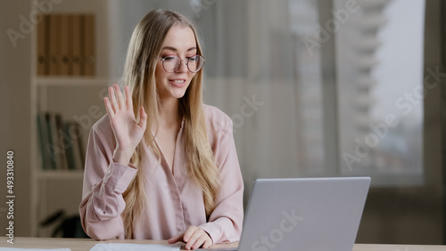Caucasian female online teacher internet coach psychologist mentor specialist e-consultant business woman with papers at table speaks in laptop webcam conference chat remote conversation consultation