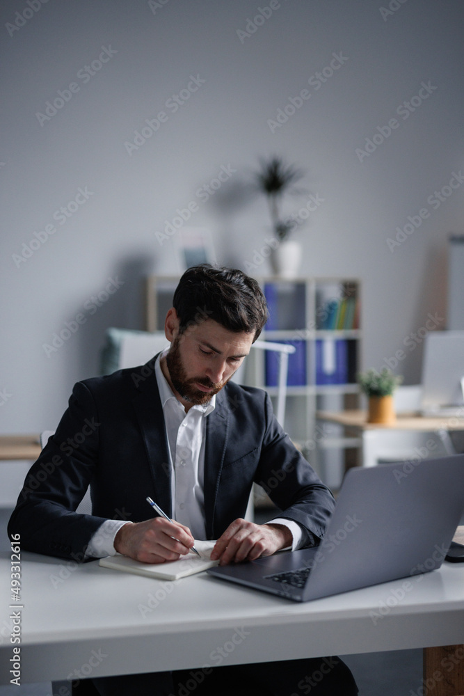Professional trader writing notes in notebook Professional trader writing notes in notebook