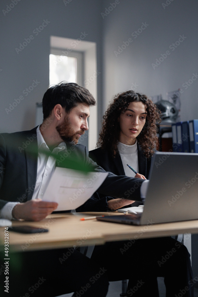 Analyst helping colleague with online stock platform Analyst helping colleague with online stock platform