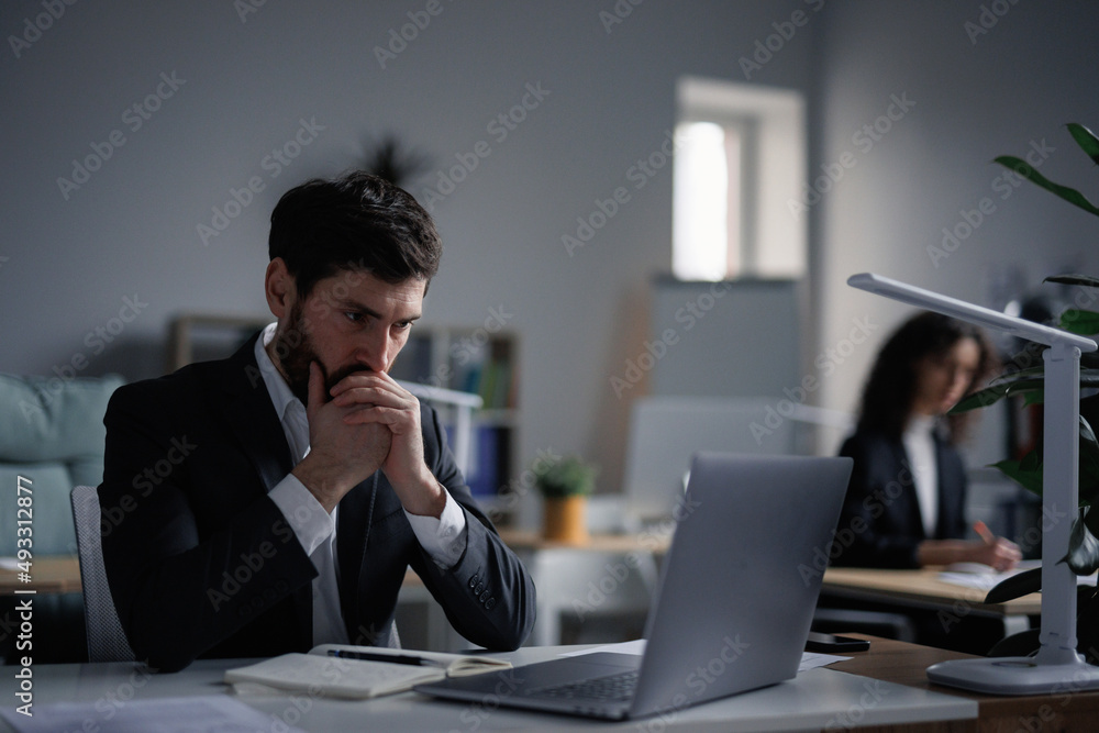 Anxiety male worker while playing stock market online Anxiety male worker while playing stock market online