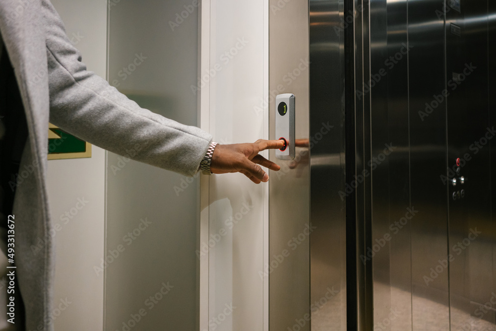 Crop person calling elevator with opening doors Crop person calling elevator with opening doors