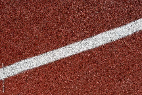 detail of the red tartan surface with white line, sporting terrain, life of the athlete