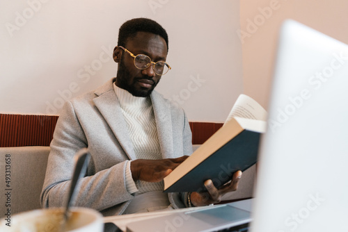 Black man reading book in cafe