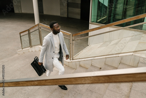Black businessman walking upstairs of office