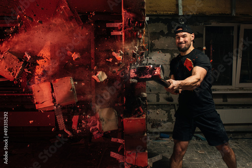 crossfit athlete crashing wall with sledgehammer photo