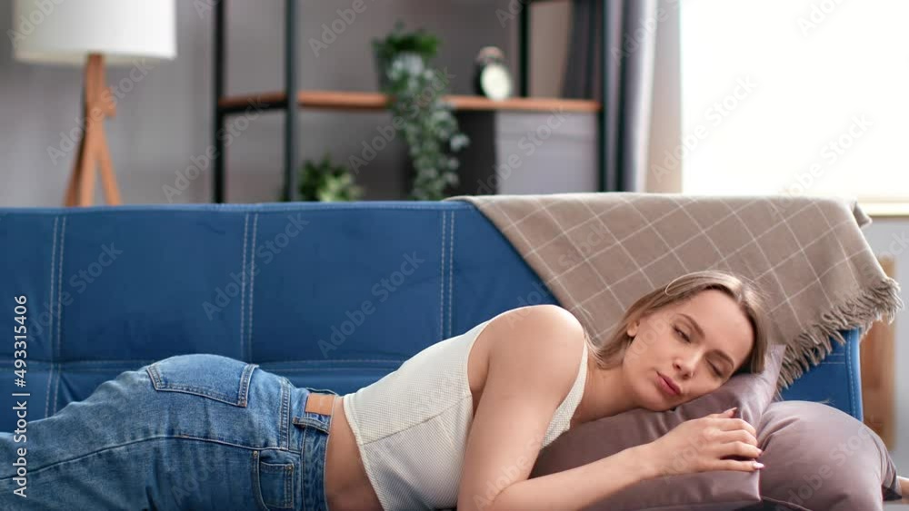 Tired young blonde woman falling down couch crying relationship problem suffering loneliness slowmo