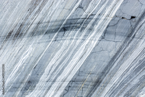 Surface of a cut of gray Karelian marble rock in Ruskeala in Karelia  for use as an abstract background and texture.