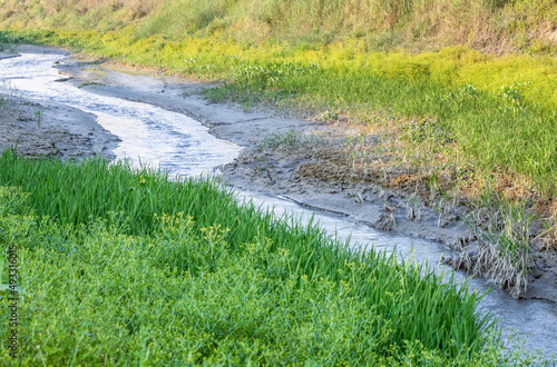 Passing water over an almost dried canal in the rural village beside the meadowland