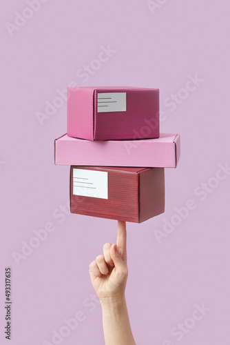 Woman holding on finger three colorful boxes photo