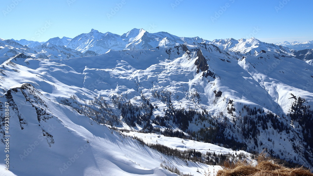 Alpine landscape in winter. Blue sky. Snow is melting. View of the snowy mountains near Rauris in Austria. Grossglockner on the horizon.