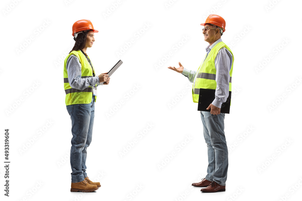 Mature male engineer talking to a young female engineer Mature male engineer talking to a young female engineer