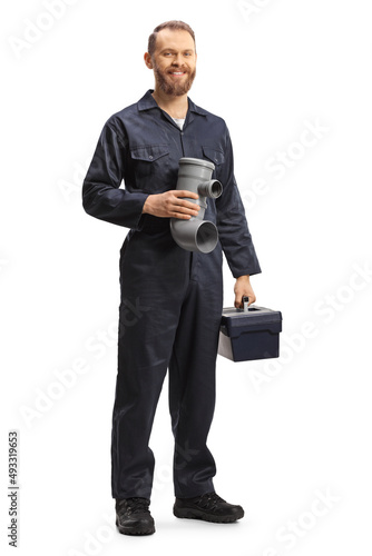 Full length portrait of a plumber holding a plastic pipe and a tool box