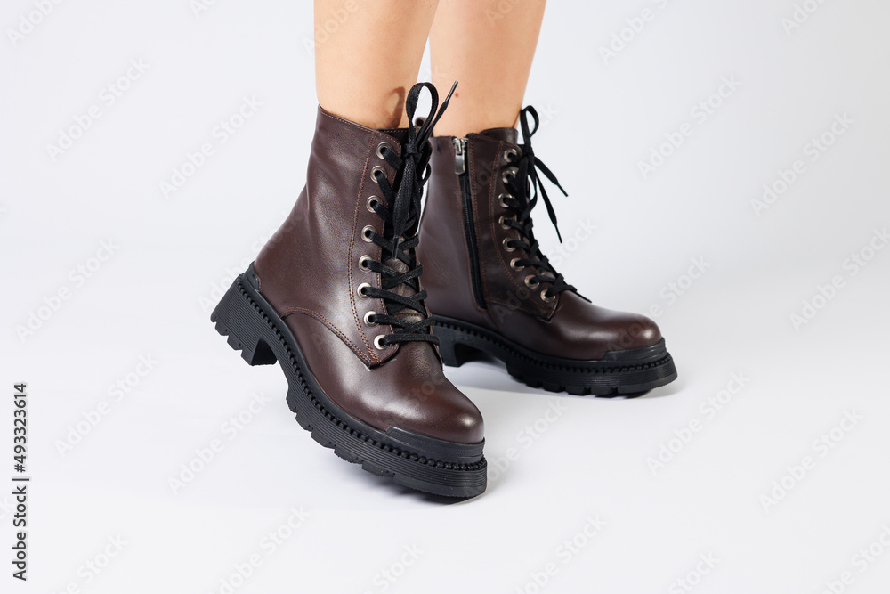 Women's brown spring boots made of genuine leather on a woman's leg. New collection of women's boots 2022 Women's brown spring boots made of genuine leather on a woman's leg. New collection of women's boots 2022