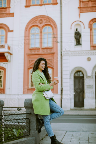 Young woman on the street holding takeaway coffee