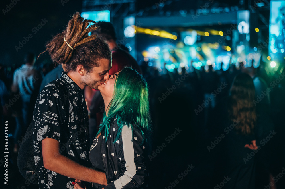 Young happy couple kissing at music festival